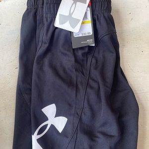 The brand is Under Armour. A size YM. Black shorts with white Under Armour logo.